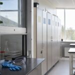 Naturfagslokale på en dansk skole med stinkskab, beskyttelsesbriller og nitrilhandsker på bordet og aflåst kemikalieskab